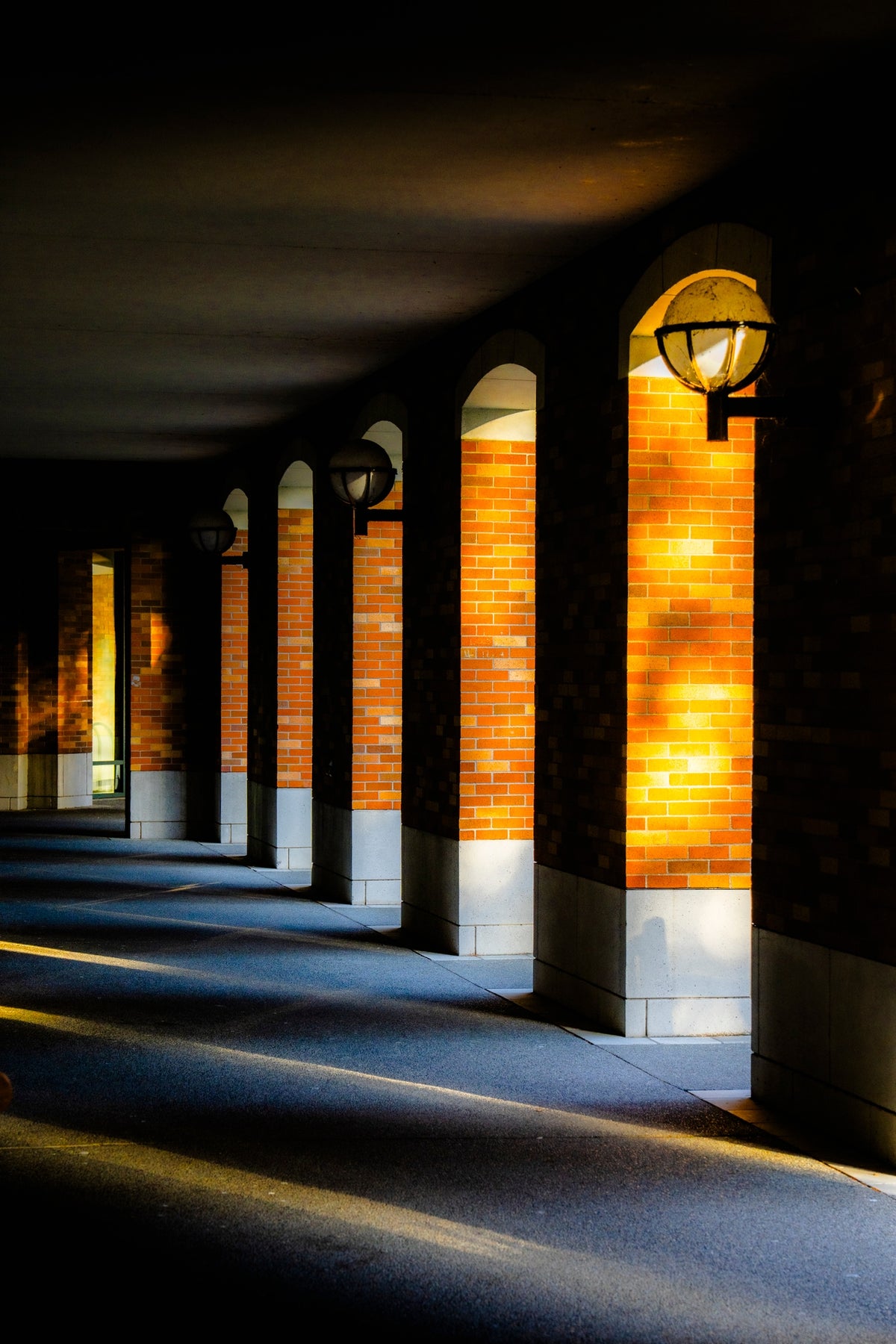 00_04 by Nick Patterson. Warm sunlight and long shadows between building columns.