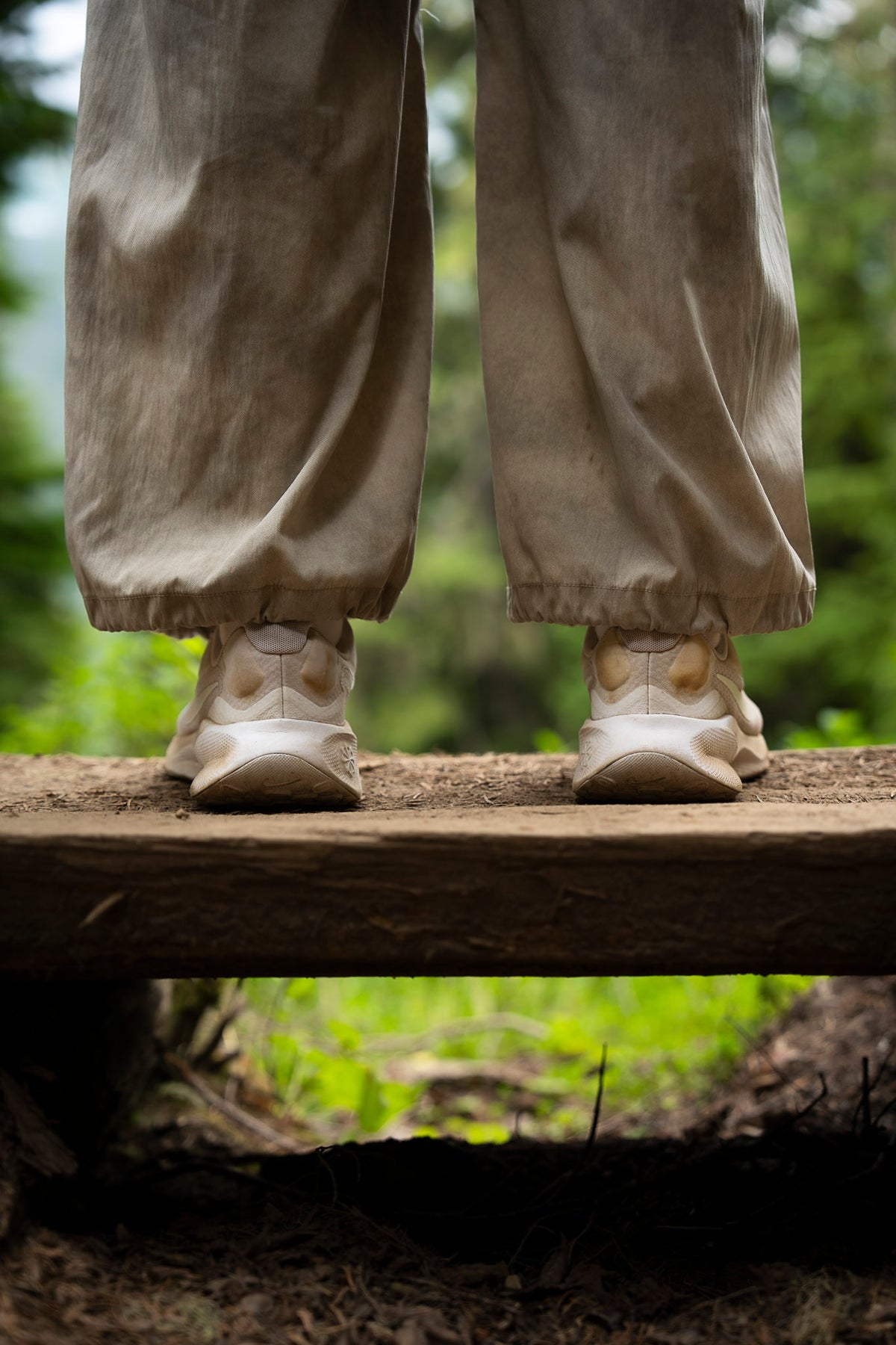 00_43 by Nick Patterson. Shoes and trouser legs on a wooden footbridge in a green forest.