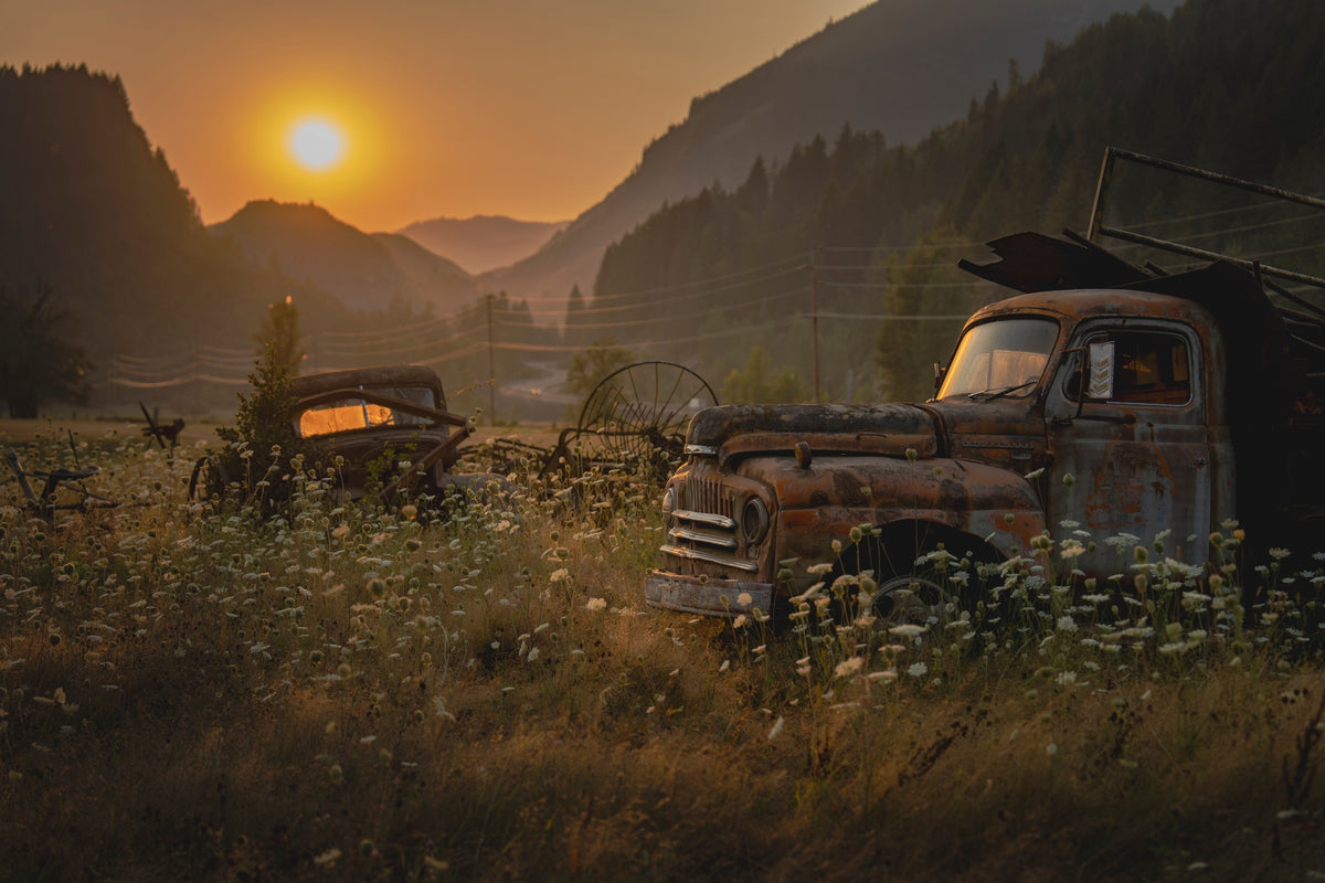00_09 by Nick Patterson. Old trucks in a mountain valley in warm, low sunlight.