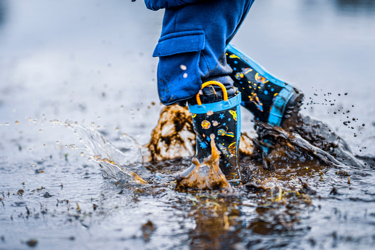 00_12 by Nick Patterson. Blue rain boots splashing through a puddle.