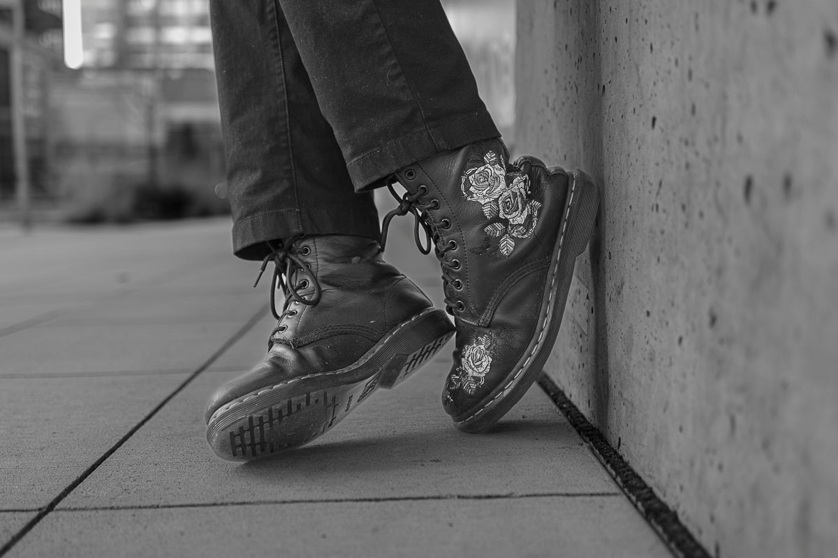 00_40 by Nick Patterson. Patterned shoes and trouser legs beside a wall in black and white.