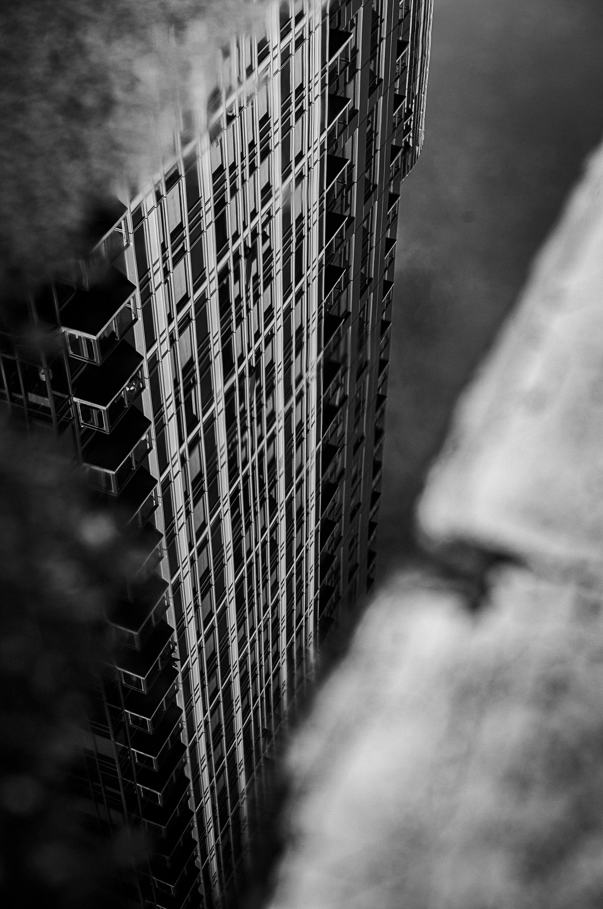 00_27 by Nick Patterson. A tall building seen between foreground shapes in black and white.
