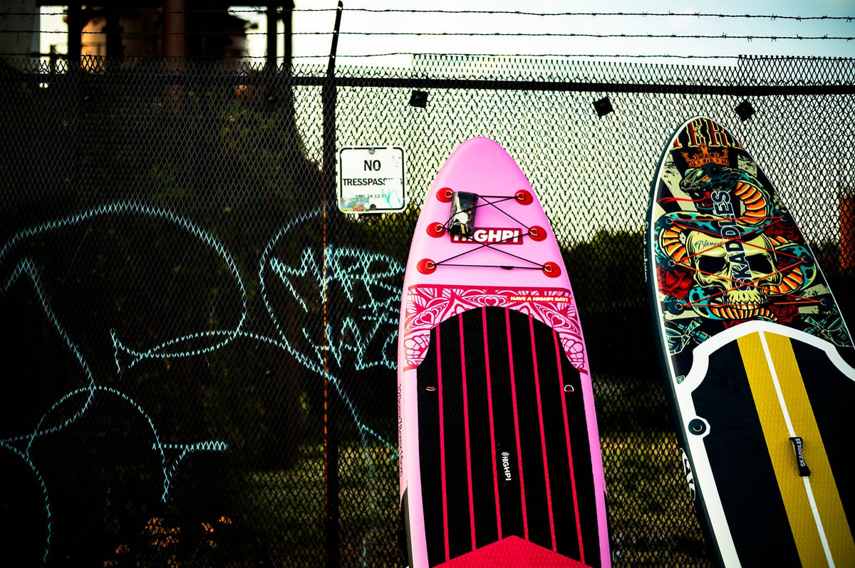 00_28 by Nick Patterson. Colorful paddleboards leaning against a fence.