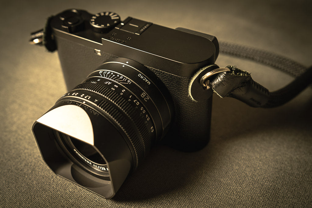 Leica Q2 Monochrom with lens hood, viewed from the front.